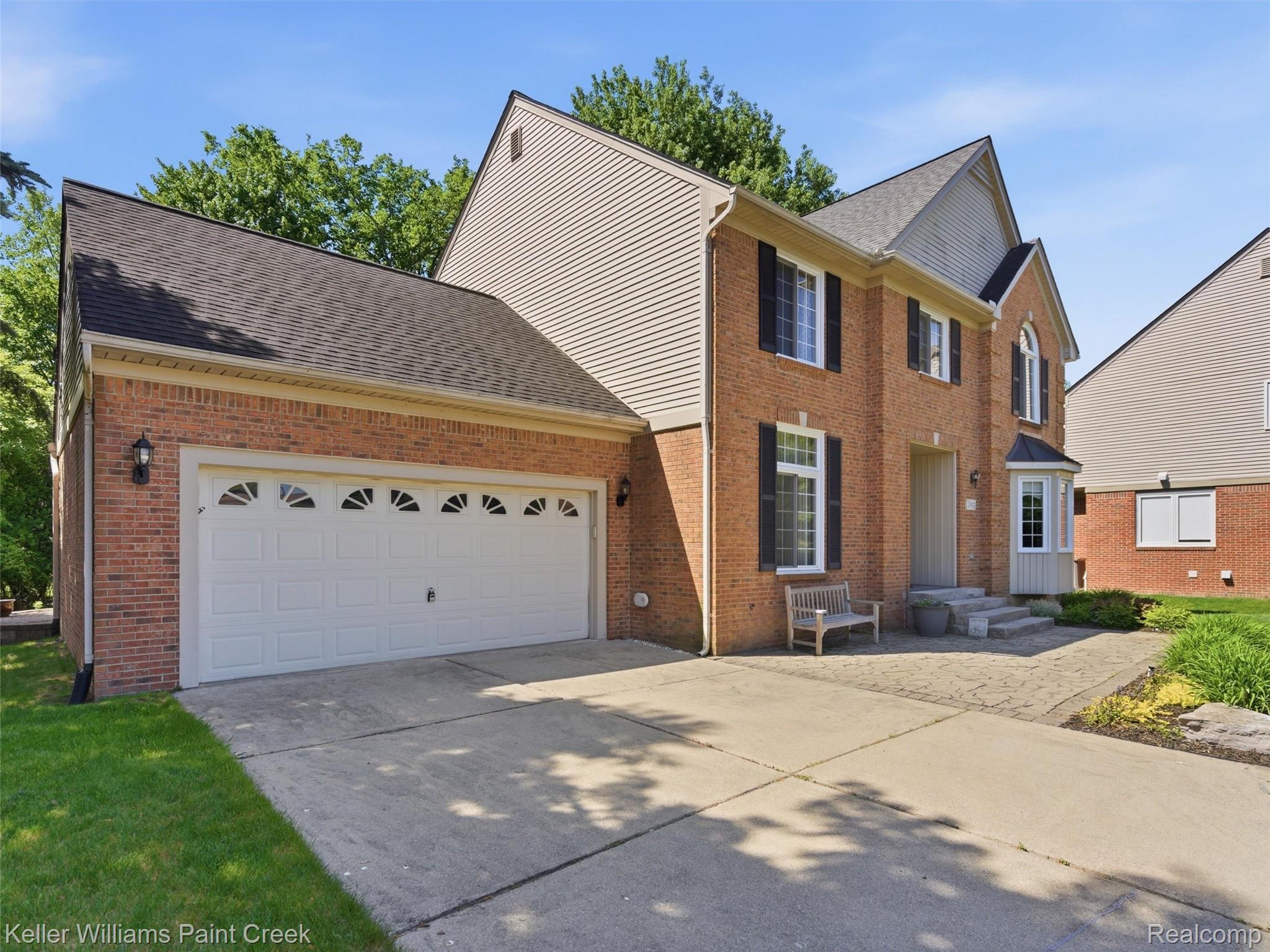 2842 Manorwood Road Troy, MI 48085 - Photo 7 of 72 Brick facade with contrasting siding, featuring a two-car garage with arched window detailing
