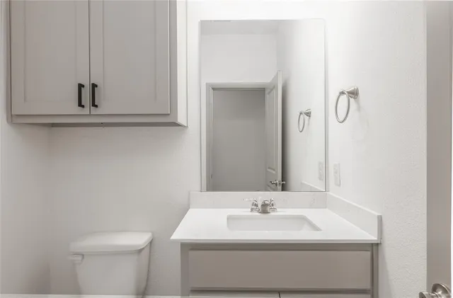 a bathroom with a sink a toilet and mirror