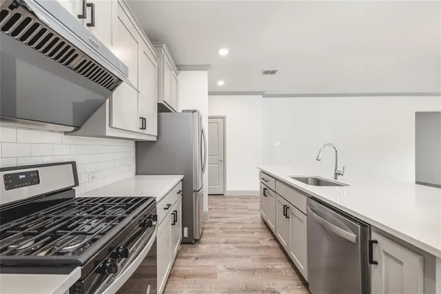 a kitchen with stainless steel appliances a sink and a stove