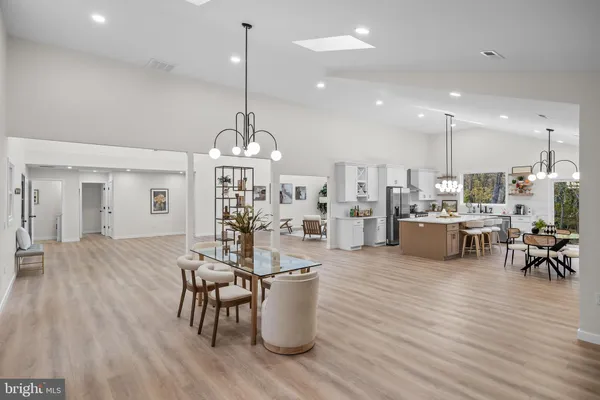 a kitchen with a dining table chairs sink and stove