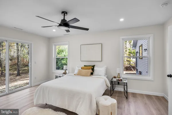 a bedroom with a bed a window and a painting on the wall