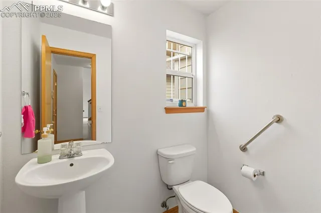 a bathroom with a toilet sink and mirror
