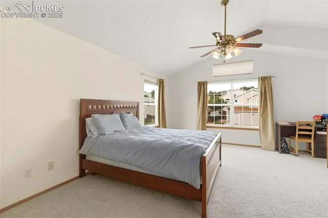 a bedroom with a bed chandelier and a window