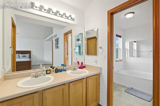 a bathroom with a sink vanity tub and a mirror