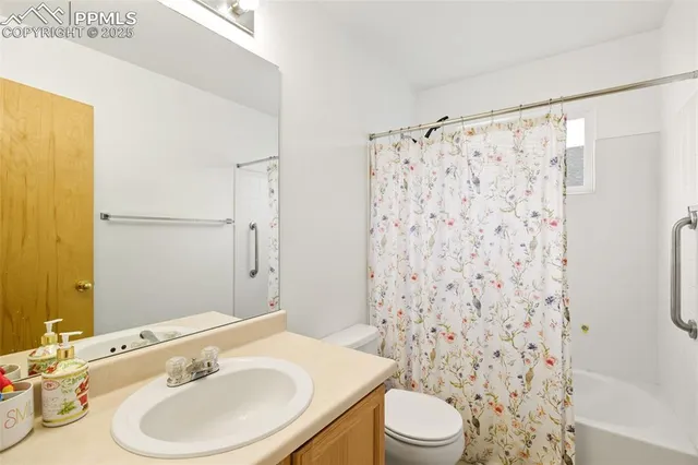 a bathroom with a sink a toilet and shower curtain