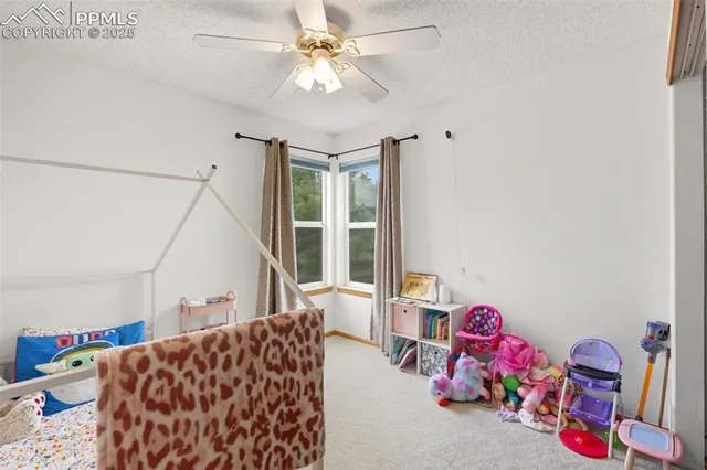 a bedroom with furniture and a chandelier fan