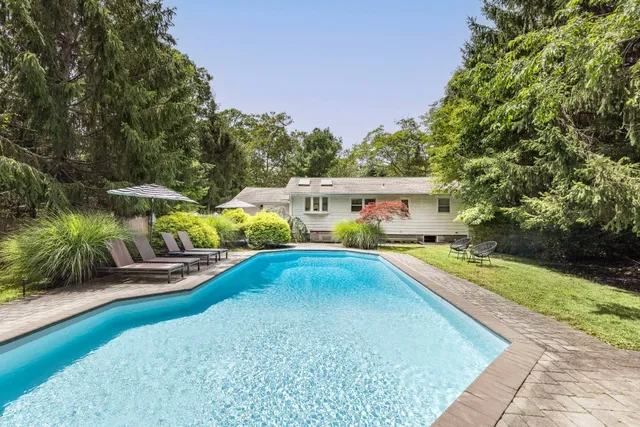 swimming pool view with a garden