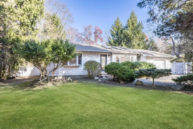a view of a house with a yard and sitting area