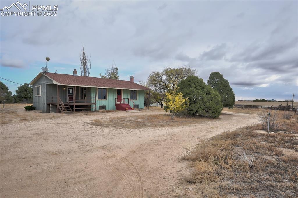 a front view of a house with a yard and potted plants