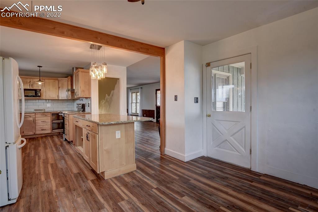 37550 Highway 94 Yoder, CO 80864 - Photo 12 of 39 a kitchen with kitchen island wooden floors appliances and cabinets