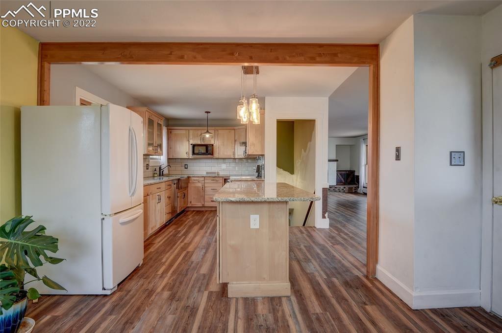 37550 Highway 94 Yoder, CO 80864 - Photo 13 of 39 a kitchen with a refrigerator a sink and wooden floor