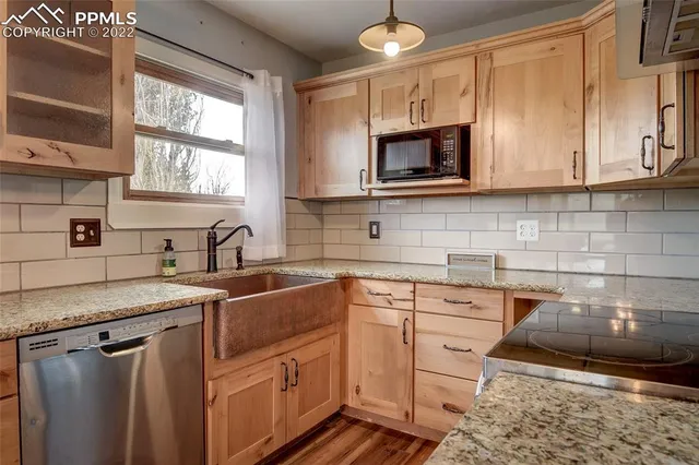 a kitchen with stainless steel appliances granite countertop a sink stove and microwave