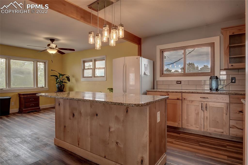 37550 Highway 94 Yoder, CO 80864 - Photo 9 of 39 a kitchen with stainless steel appliances granite countertop a stove a sink and a refrigerator with wooden floors