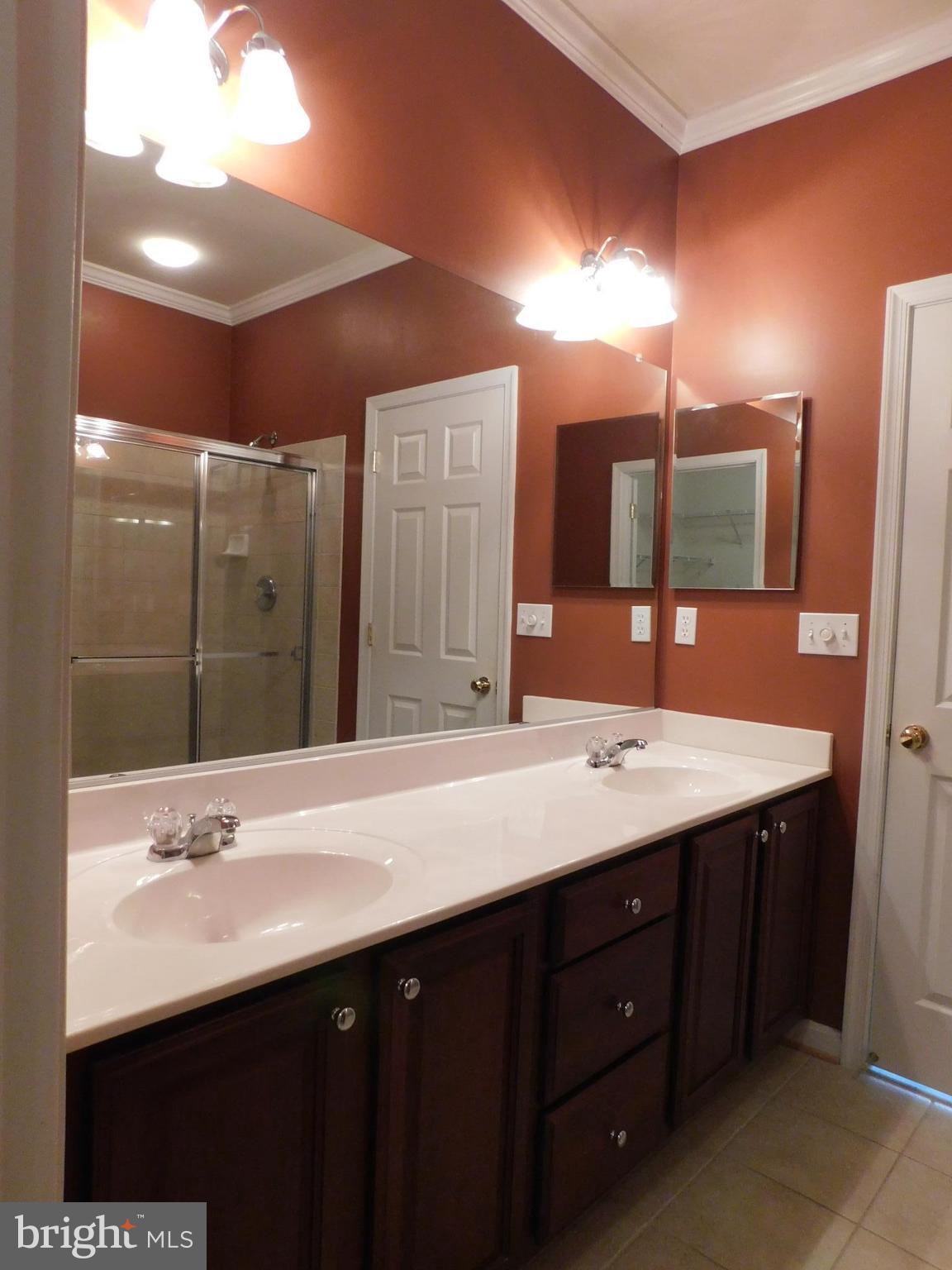 14162 Foxhall Road, Unit 4 Dowell, MD 20629 - Photo 11 of 24 a bathroom with a double vanity sink and a mirror