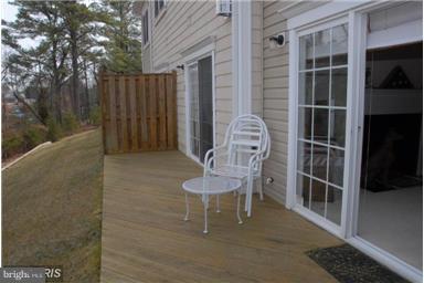 14162 Foxhall Road, Unit 4 Dowell, MD 20629 - Photo 16 of 24 a porch with a chair and a table in a patio