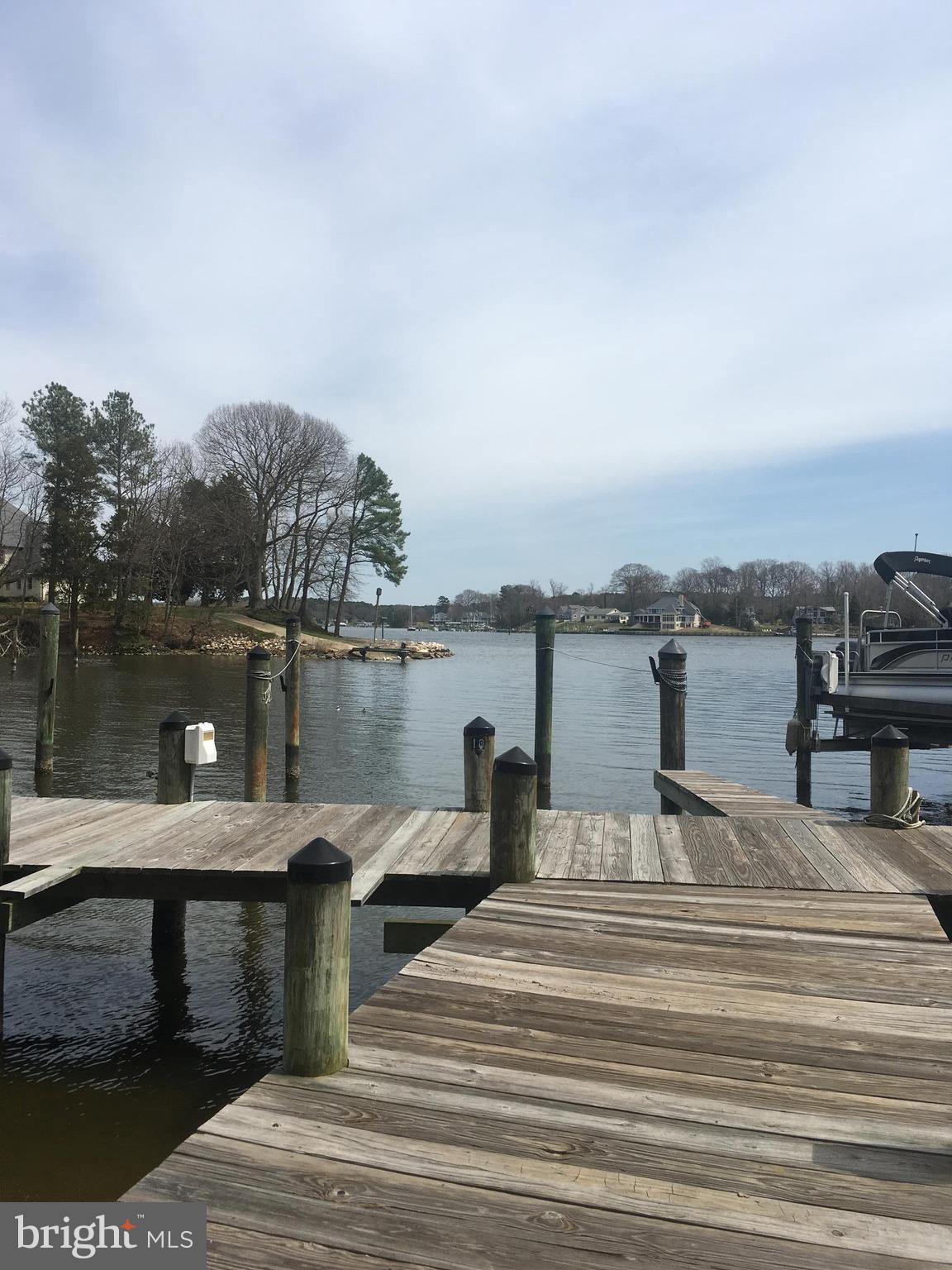 14162 Foxhall Road, Unit 4 Dowell, MD 20629 - Photo 18 of 24 a view of a lake with boats and trees in the background