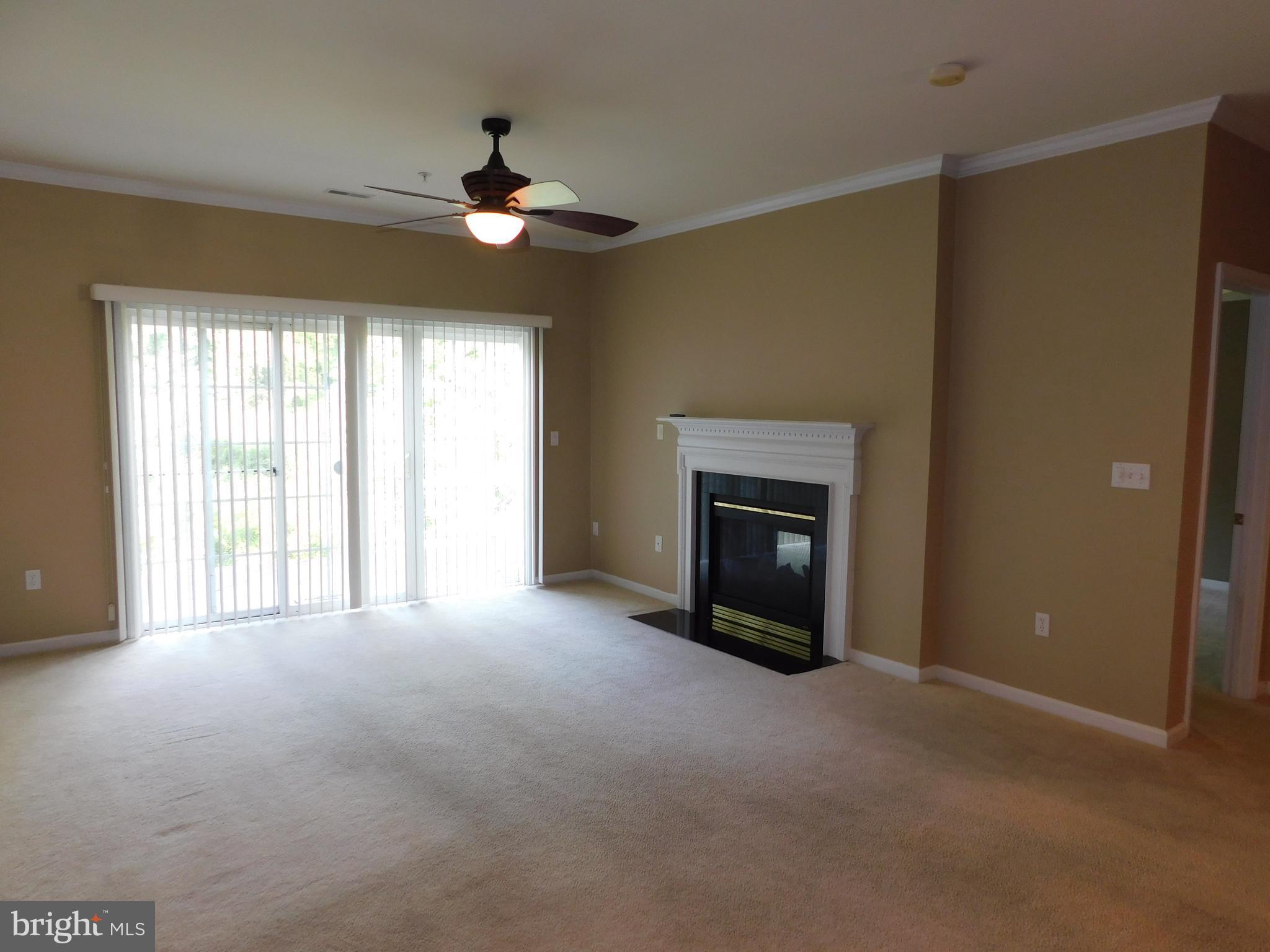 14162 Foxhall Road, Unit 4 Dowell, MD 20629 - Photo 5 of 24 a view of an empty room with a fireplace and a window