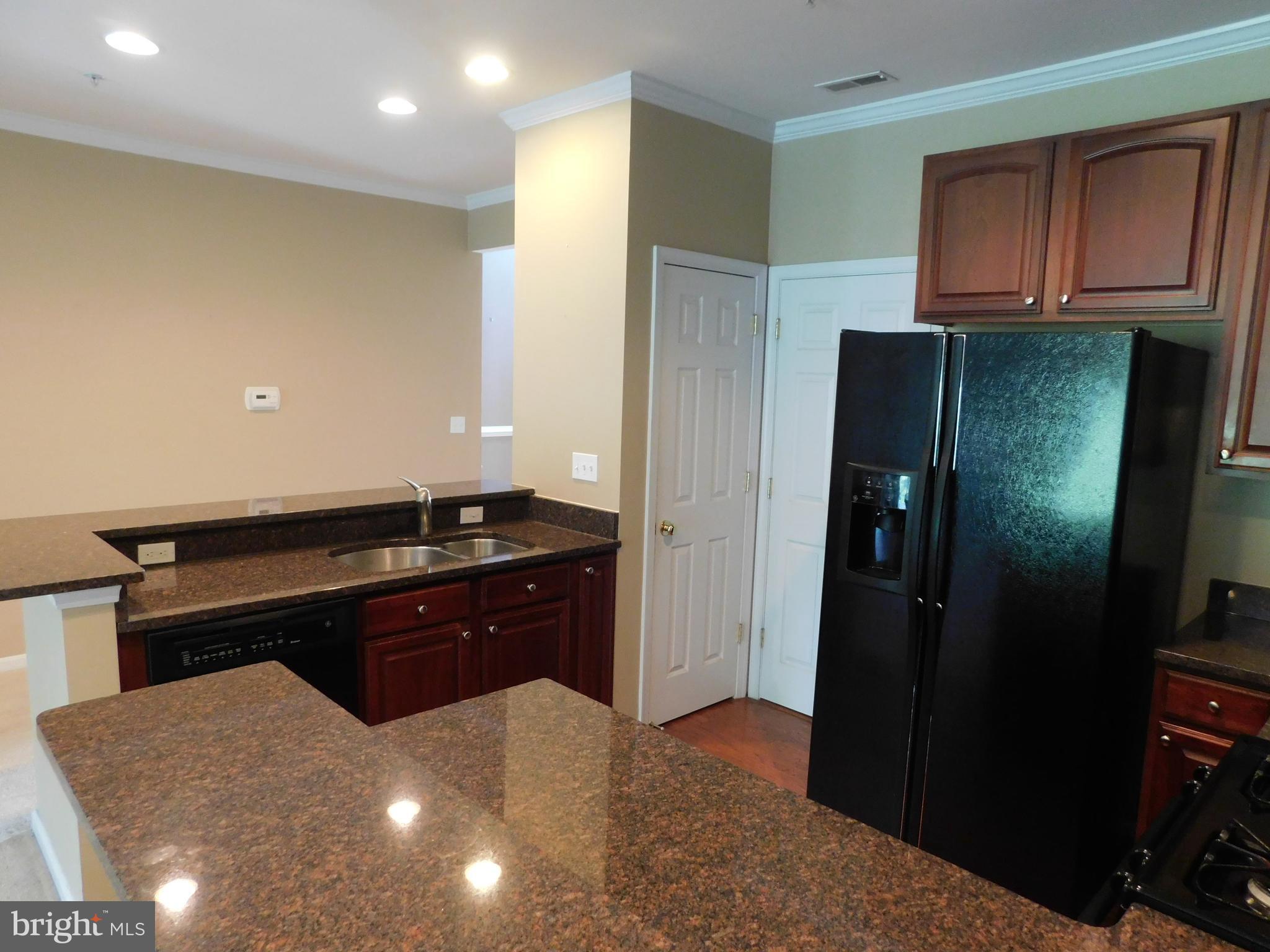 14162 Foxhall Road, Unit 4 Dowell, MD 20629 - Photo 7 of 24 a kitchen with a sink and refrigerator
