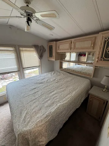 a spacious bedroom with a bed next to a large window with storage