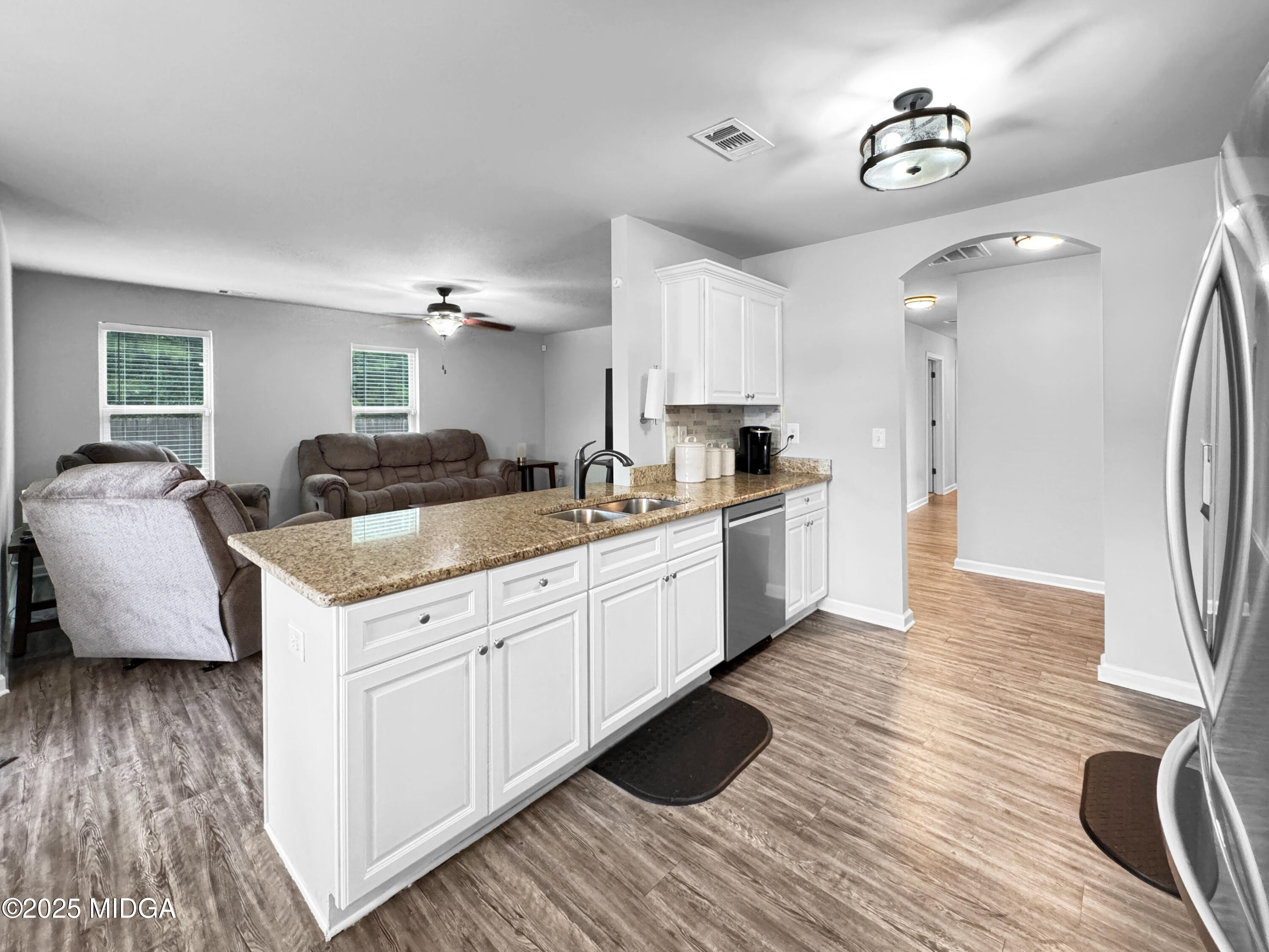 837 Weldon Road Forsyth, GA 31029 - Photo 5 of 24 a kitchen with granite countertop a stove top oven a sink dishwasher a dining table and chairs with wooden floor
