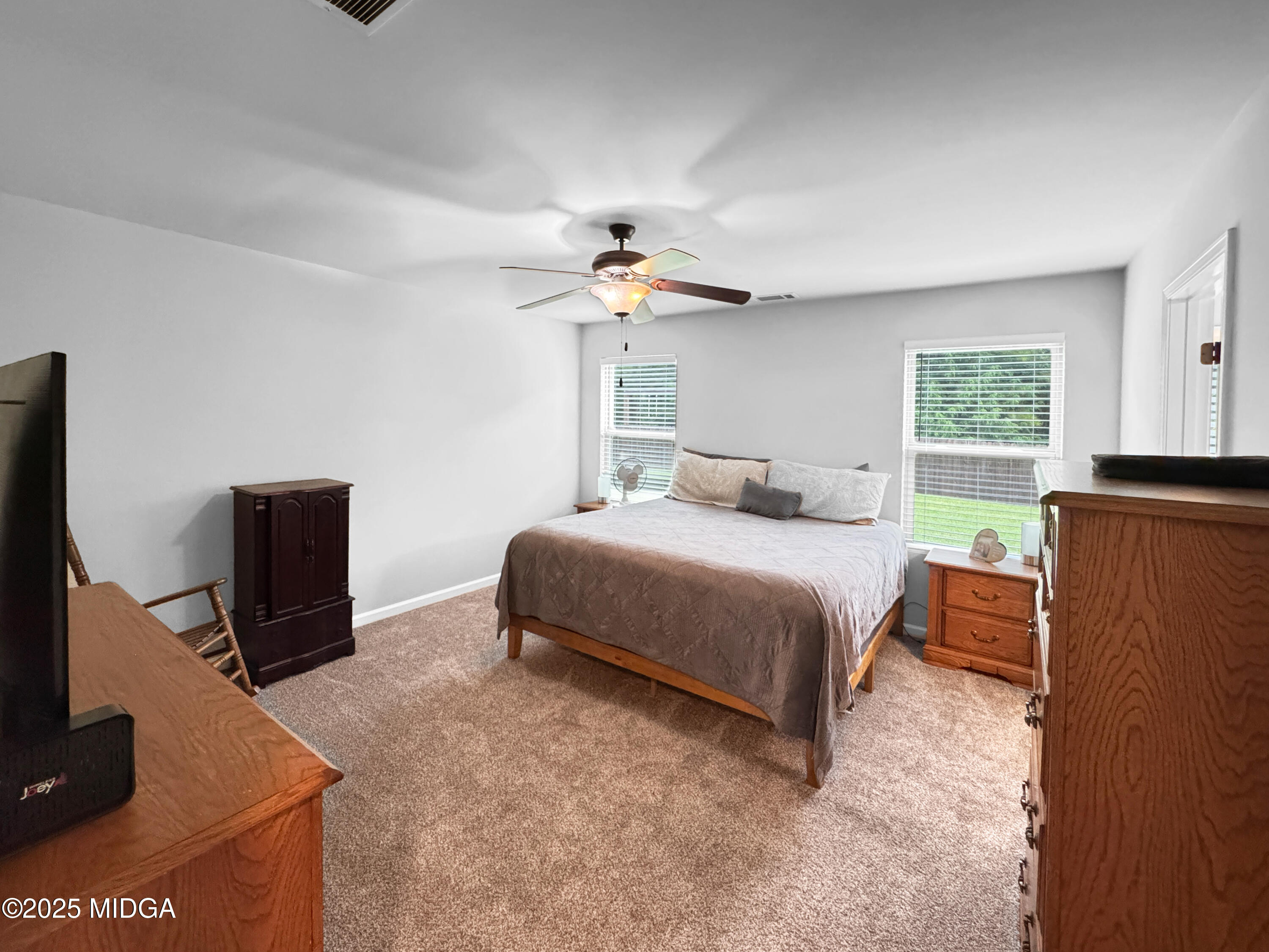 837 Weldon Road Forsyth, GA 31029 - Photo 10 of 24 a bedroom with a bed and a flat tv screen on a dresser