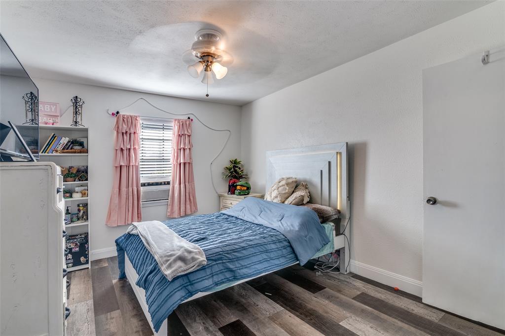 5610 Magnolia Lane Rowlett, TX 75089 - Photo 17 of 25 a bedroom with a large bed and a chandelier