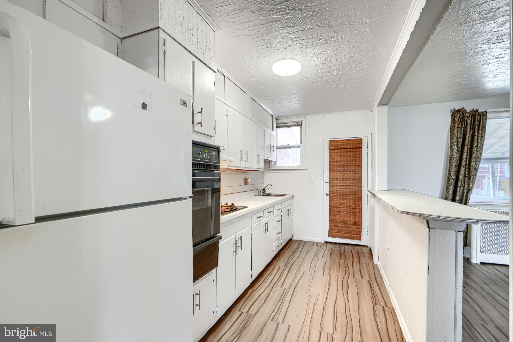 1302 Edison Highway Baltimore, MD 21213 - Photo 11 of 27 a kitchen with cabinets a sink and a refrigerator