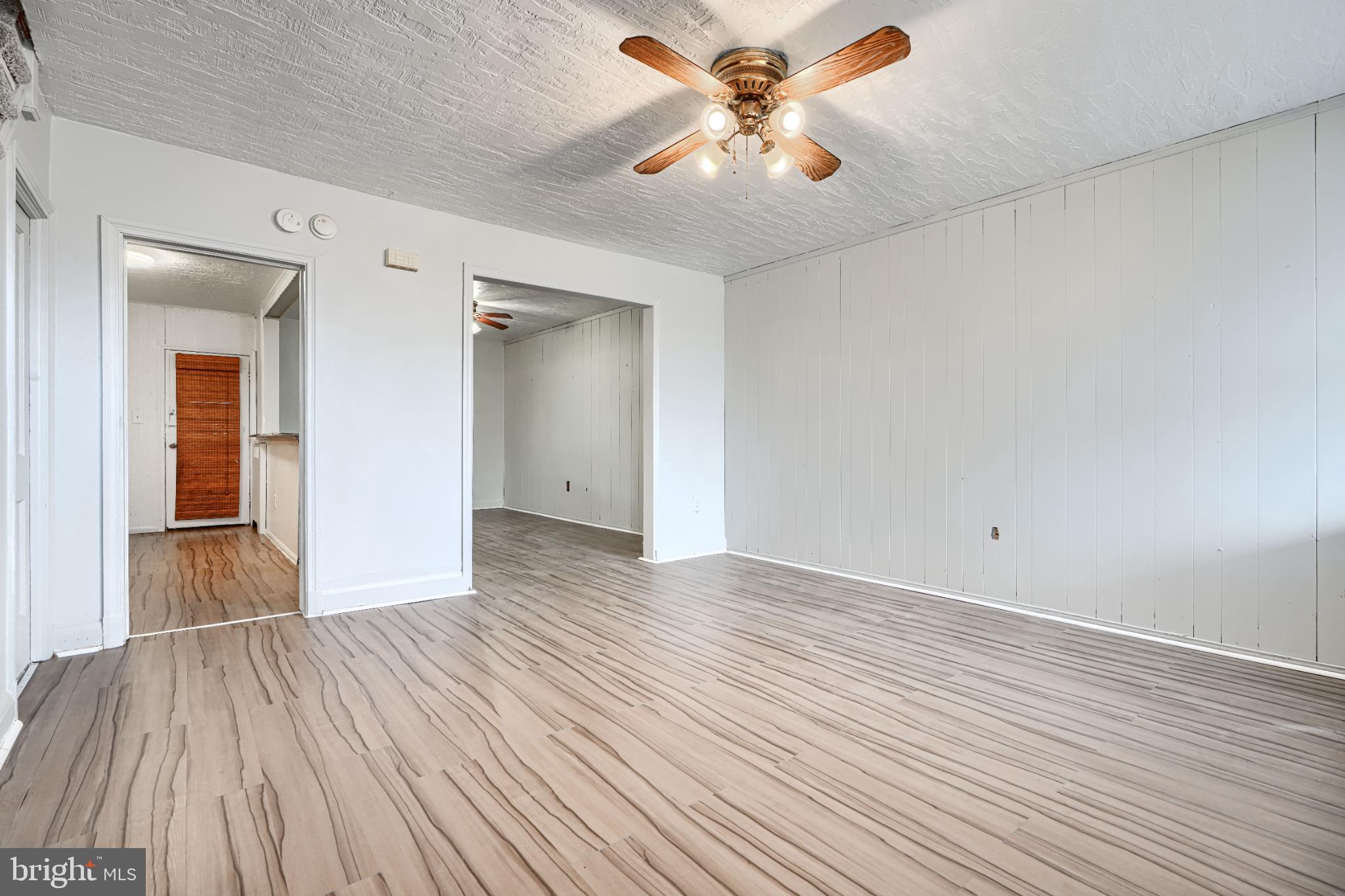 1302 Edison Highway Baltimore, MD 21213 - Photo 4 of 27 wooden floor in an empty room with a window