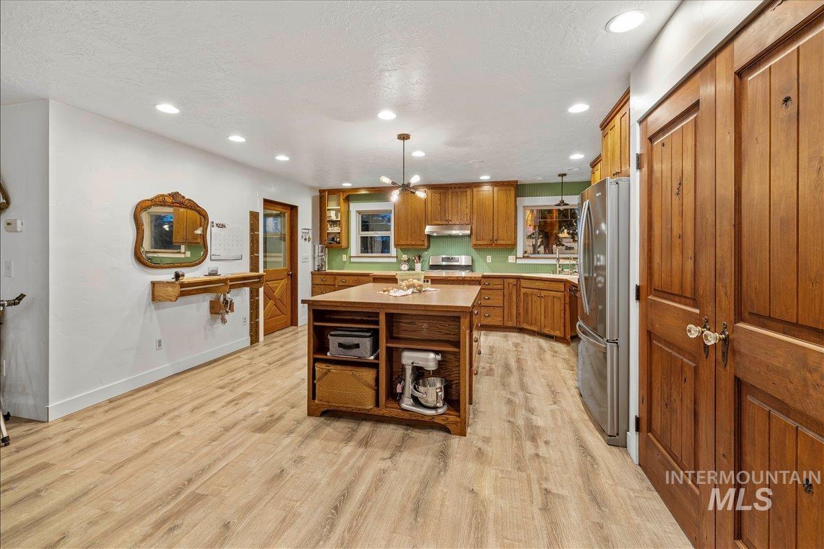 6712 Stage Coach Road Nampa, ID 83686 - Photo 5 of 48 Expansive property featuring a main residence with a gabled roof and chimney, multiple outbuildings including a large barn with a pitched roof, and a separate green-roofed structure