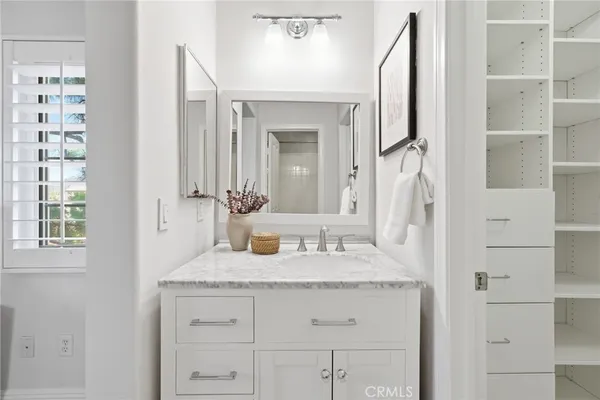 a bathroom with a granite countertop sink vanity and mirror