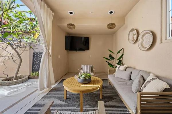 a living room with furniture a flat screen tv and a floor to ceiling window