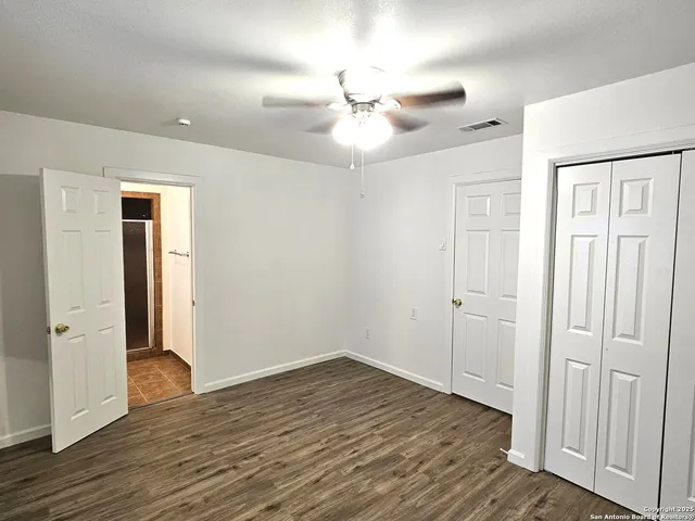 a view of an empty room with wooden floor