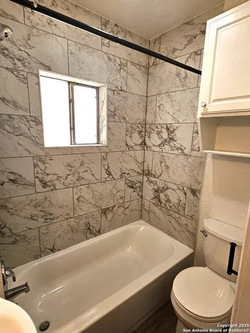 a bathroom with a toilet a sink and bathtub