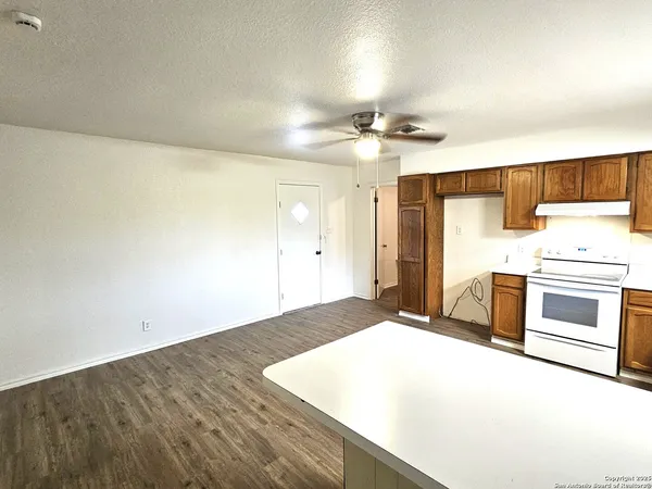 a kitchen with granite countertop a stove a sink and a refrigerator