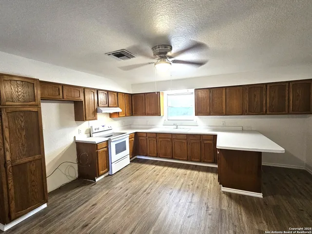 a kitchen with stainless steel appliances wooden floors and view living room