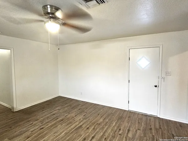 a view of an empty room with wooden floor