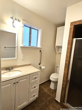 a bathroom with a granite countertop sink toilet and mirror