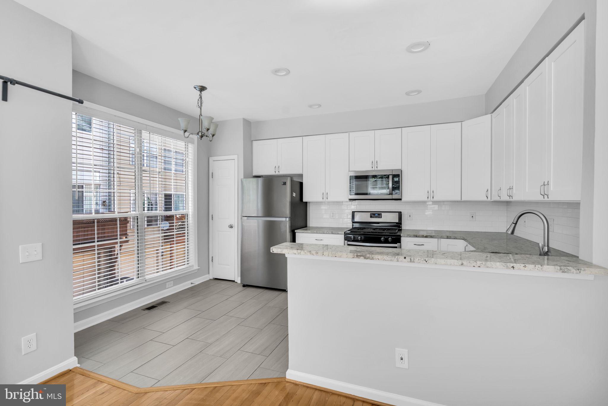 6013 Riddle Walk Alexandria, VA 22312 - Photo 11 of 31 a kitchen with stainless steel appliances granite countertop a refrigerator sink and stove