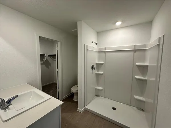 a bathroom with a shower sink and toilet