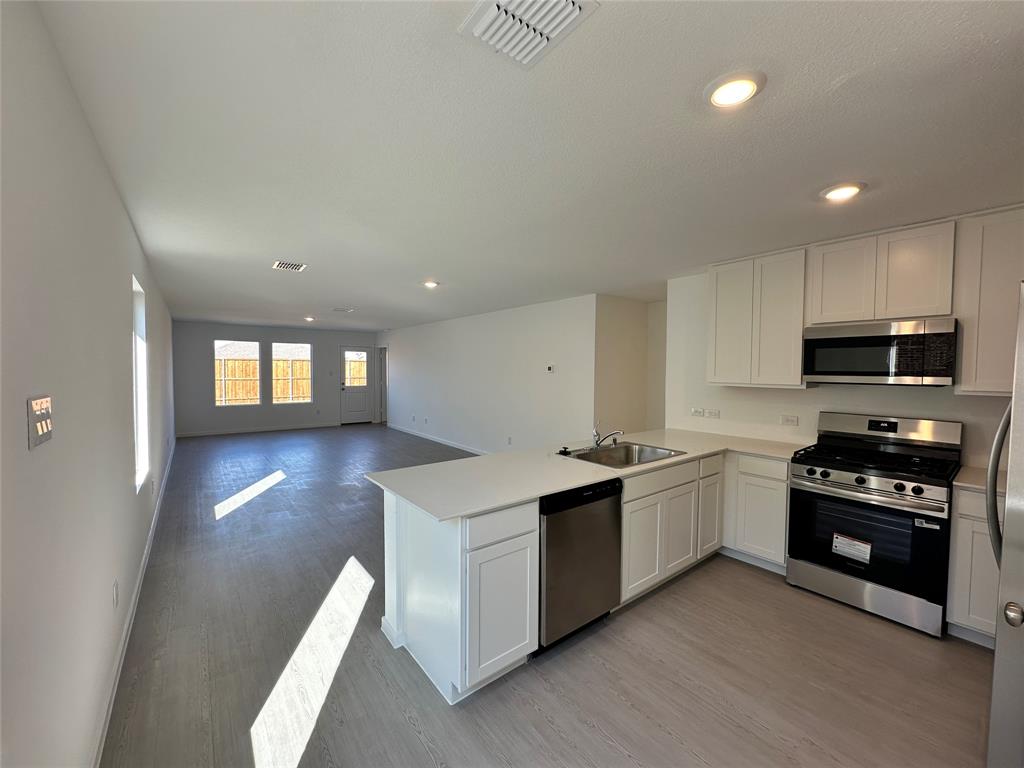 1617 Elliott Road Howe, TX 75459 - Photo 4 of 14 a kitchen with stainless steel appliances granite countertop a stove a sink and a refrigerator
