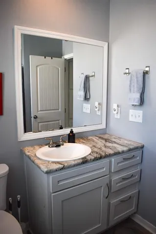 a bathroom with a granite countertop sink and a mirror