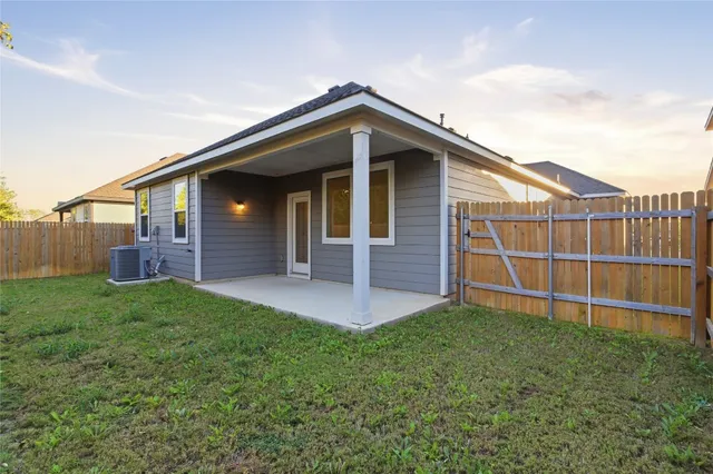 a view of a house with a yard and fence