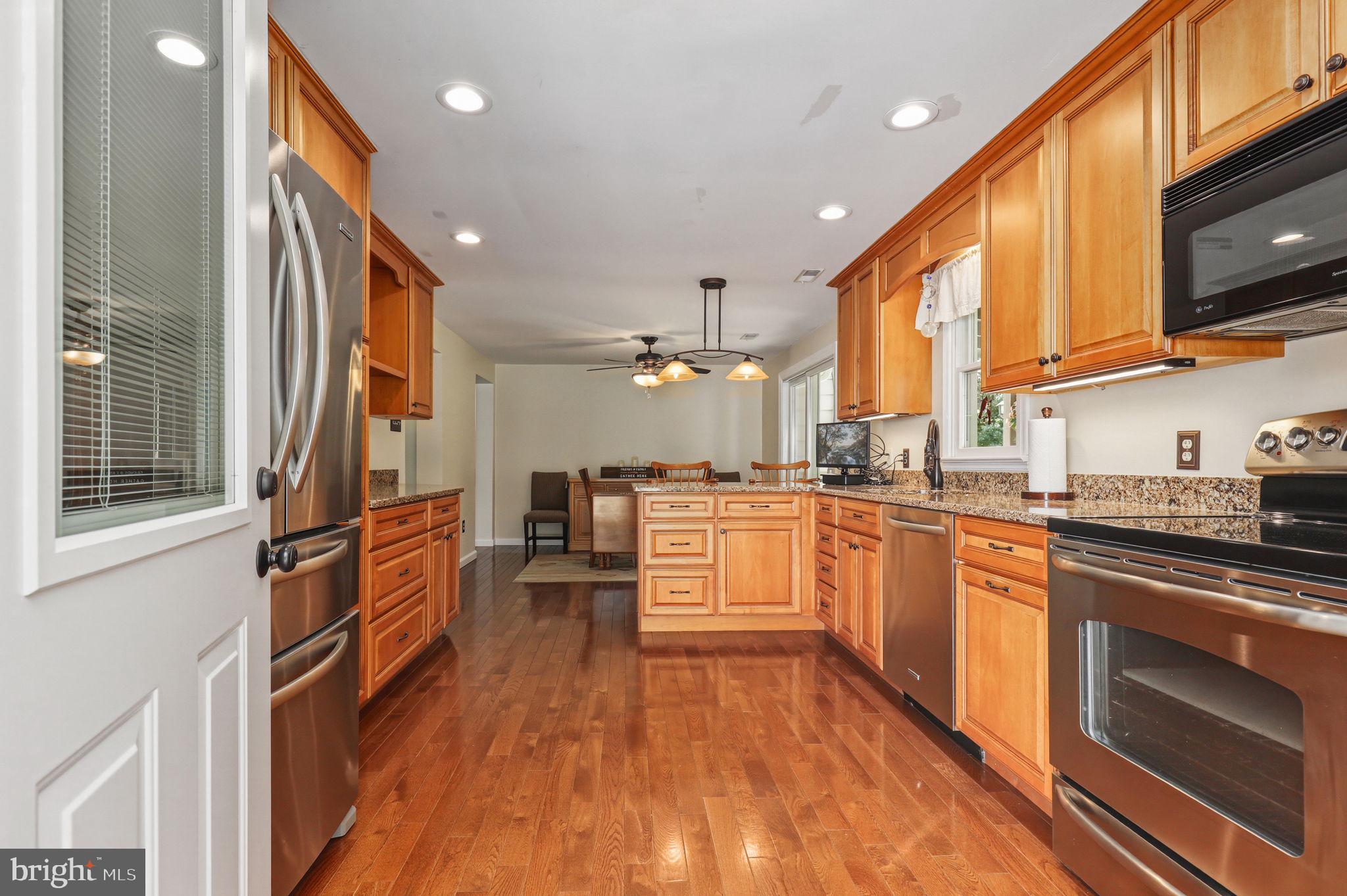 6336 Boyers Mill Road New Market, MD 21774 - Photo 11 of 49 a kitchen with stainless steel appliances granite countertop wooden floors a stove and a refrigerator