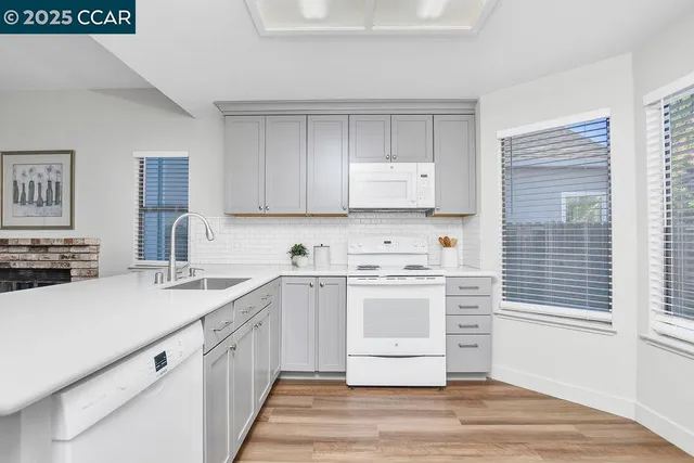 a kitchen with granite countertop a sink stove and cabinets