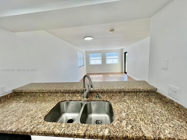 a kitchen with a sink and granite top