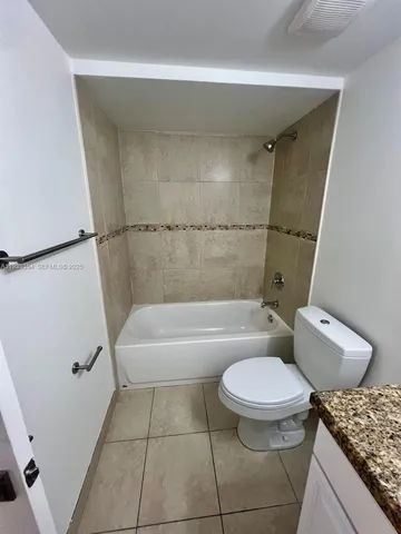 a bathroom with a granite countertop toilet a sink and a bathtub