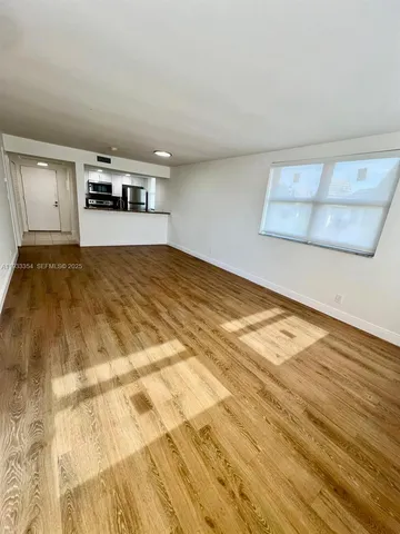 a bedroom with a bed and a wooden floor