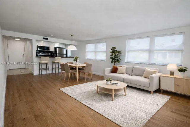 a living room with furniture a window and a flat screen tv