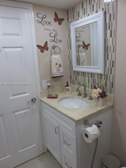 7040 Southwest 24th Street, Unit 104 Miami, FL 33155 - Photo 14 of 27 a bathroom with a granite countertop sink mirror vanity and toilet