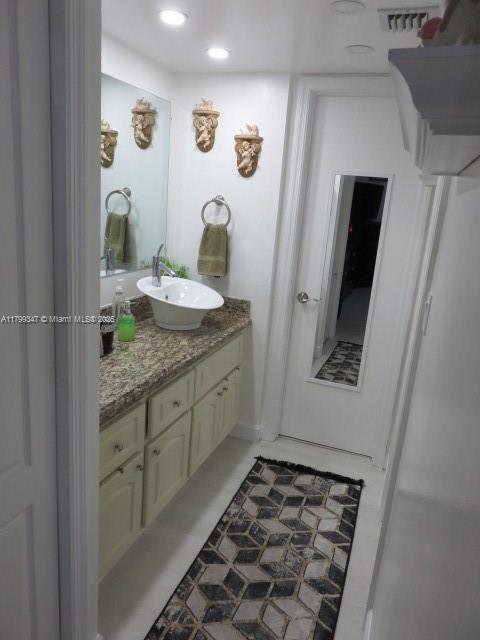 7040 Southwest 24th Street, Unit 104 Miami, FL 33155 - Photo 19 of 27 a bathroom with a granite countertop sink and a mirror